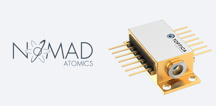 Neben dem Nomad Atomics-Logo und dem TOPTICA-Label ist auf dem Gerät eine goldfarbene elektronische Komponente mit mehreren Pins abgebildet.